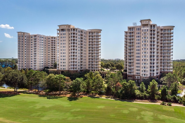 surrounding community with view of golf course and a lawn