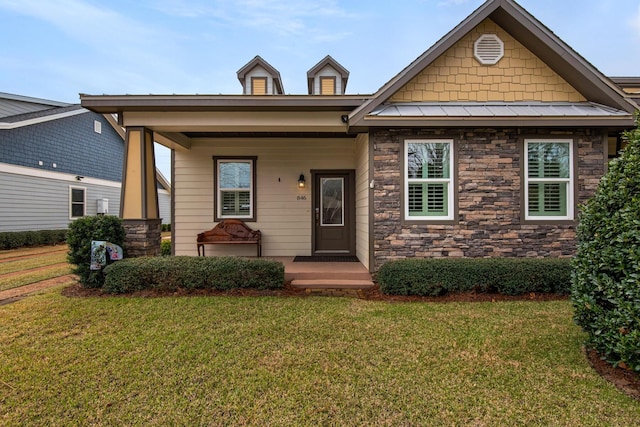 craftsman-style home with a standing seam roof, metal roof, a front lawn, and covered porch