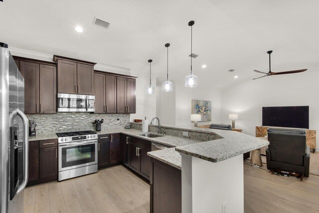 846 Cannon Ln, Destin, FL 32541 - kitchen with appliances with stainless steel finishes, open floor plan, a peninsula, hanging light fixtures, and a sink