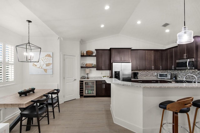 846 Cannon Ln, Destin, FL 32541 - kitchen featuring wine cooler, hanging light fixtures, appliances with stainless steel finishes, dark brown cabinets, and light stone countertops