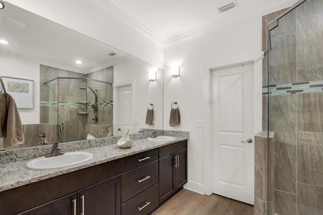 846 Cannon Ln, Destin, FL 32541 - full bathroom featuring a stall shower, visible vents, ornamental molding, wood finished floors, and a sink