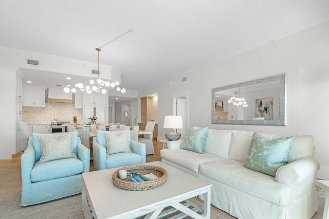 living room featuring ornamental molding, visible vents, and a notable chandelier