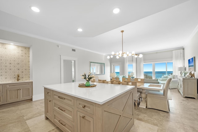 kitchen with a kitchen island, open floor plan, hanging light fixtures, light countertops, and a sink