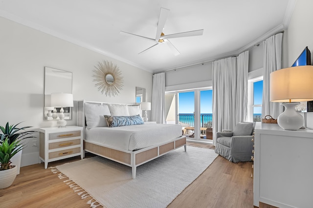 bedroom with a water view, access to exterior, light wood-style flooring, and crown molding