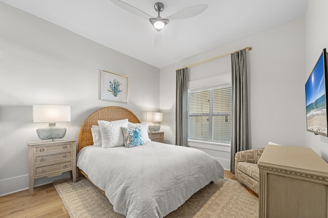 bedroom with ceiling fan, light wood-style flooring, and baseboards