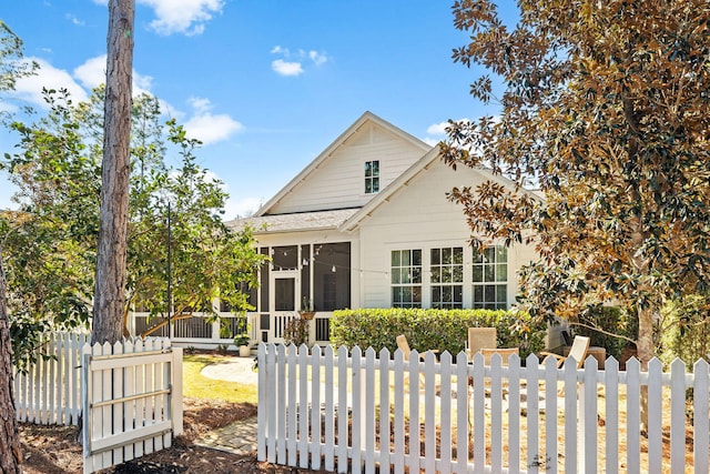 view of front of property featuring a fenced front yard and a sunroom