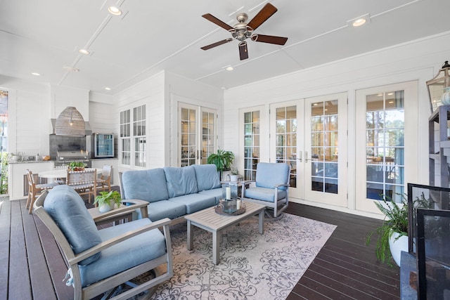 sunroom / solarium with a ceiling fan and french doors