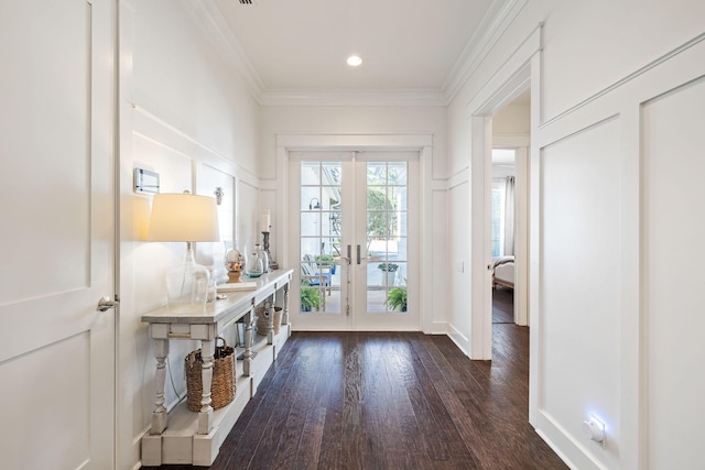 entryway with crown molding, french doors, dark wood-type flooring, and a decorative wall