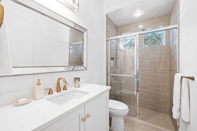 full bathroom with toilet, a shower stall, and vanity