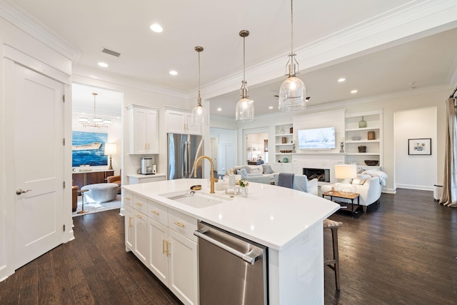 kitchen with visible vents, appliances with stainless steel finishes, a fireplace, white cabinetry, and a sink