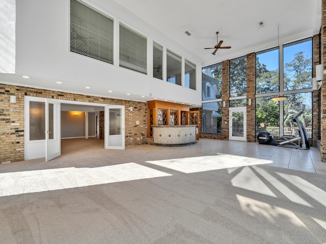 unfurnished sunroom with french doors, visible vents, a fireplace, and a ceiling fan