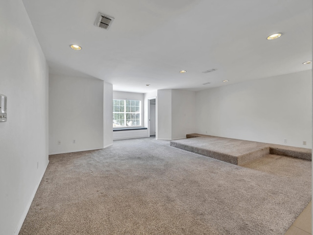 carpeted empty room featuring visible vents, recessed lighting, and baseboards