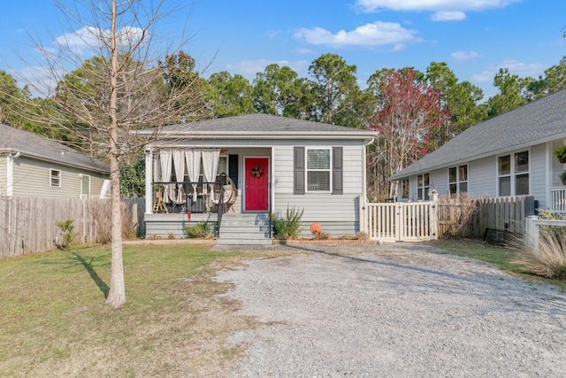 79 N 6th St, Santa Rosa Beach, FL 32459 - bungalow with a porch, a front yard, fence, and gravel driveway