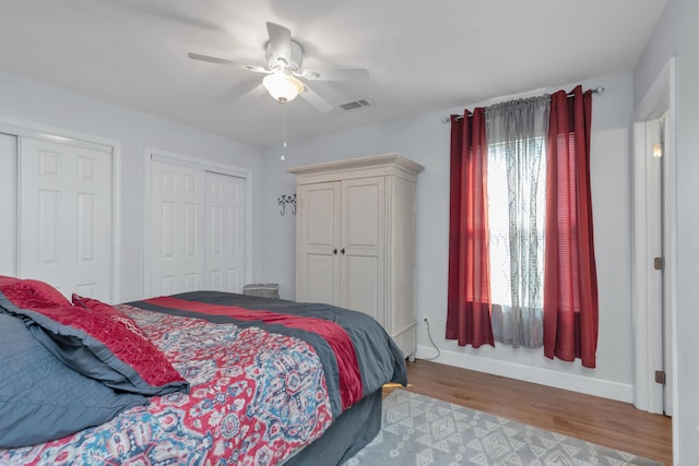 79 N 6th St, Santa Rosa Beach, FL 32459 - bedroom with two closets, visible vents, a ceiling fan, wood finished floors, and baseboards