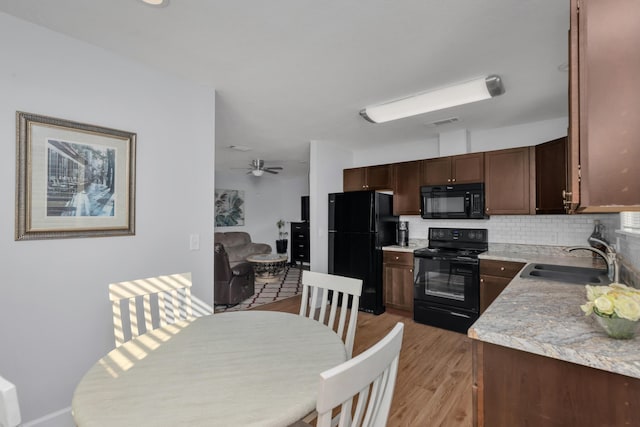 79 N 6th St, Santa Rosa Beach, FL 32459 - kitchen with light wood finished floors, visible vents, decorative backsplash, black appliances, and a sink