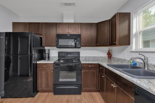 79 N 6th St, Santa Rosa Beach, FL 32459 - kitchen featuring visible vents, light countertops, light wood-type flooring, black appliances, and a sink