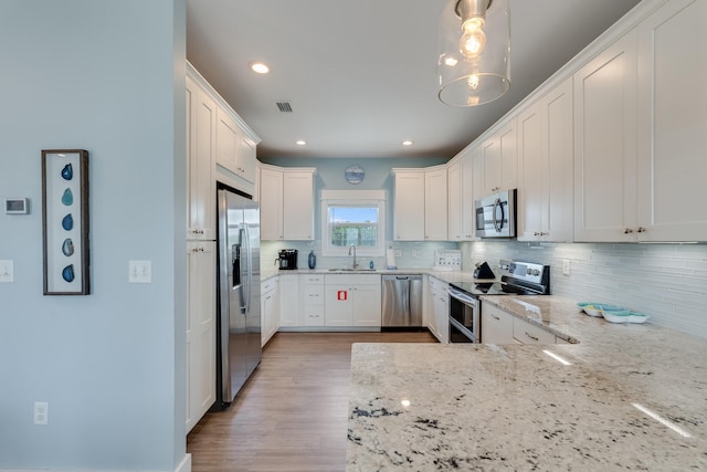 3625 Cape San Blas Rd, Cape San Blas, FL 32456 - kitchen with visible vents, backsplash, white cabinetry, appliances with stainless steel finishes, and light stone countertops