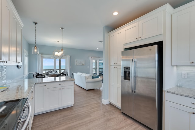 3625 Cape San Blas Rd, Cape San Blas, FL 32456 - kitchen featuring tasteful backsplash, light wood-type flooring, range with electric stovetop, white cabinets, and stainless steel fridge