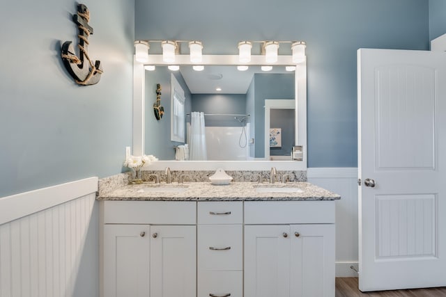 3625 Cape San Blas Rd, Cape San Blas, FL 32456 - full bathroom with double vanity, curtained shower, wainscoting, and a sink