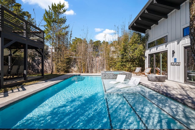 pool featuring an outdoor hot tub and a patio