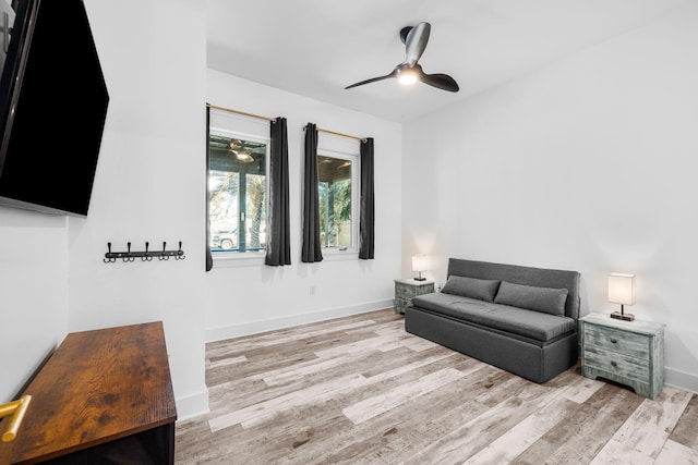 living area with ceiling fan, baseboards, and wood finished floors