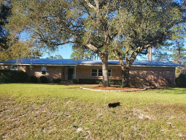 single story home featuring brick siding and a front lawn