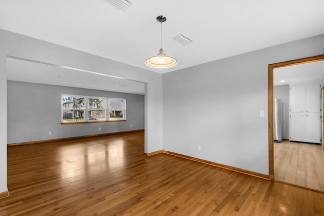 interior space with baseboards, visible vents, and light wood finished floors