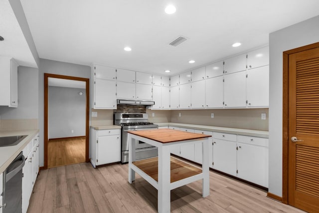 kitchen featuring visible vents, under cabinet range hood, white cabinetry, appliances with stainless steel finishes, and light countertops