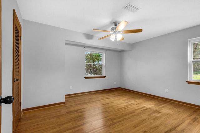 unfurnished room with visible vents, plenty of natural light, baseboards, and light wood finished floors