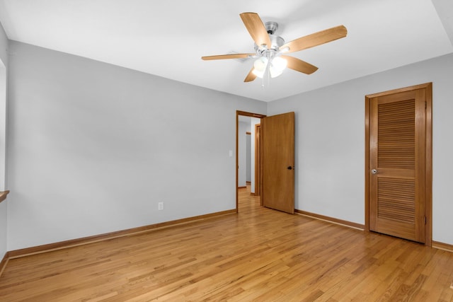 unfurnished bedroom featuring a closet, baseboards, a ceiling fan, and light wood finished floors