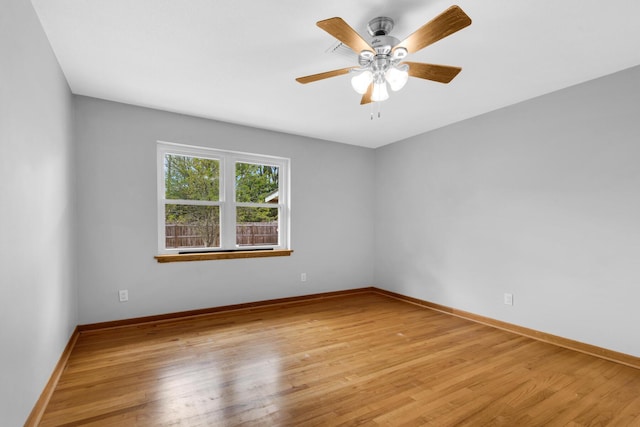 unfurnished room with light wood-style flooring, a ceiling fan, and baseboards