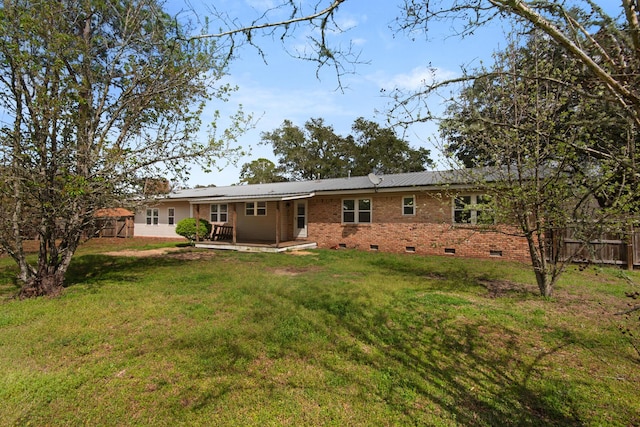 back of house featuring fence, a yard, crawl space, a deck, and brick siding