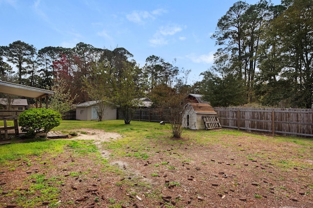 view of yard with an outdoor structure, a fenced backyard, and a shed