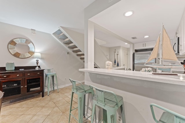 interior space with visible vents, baseboards, appliances with stainless steel finishes, light tile patterned flooring, and recessed lighting