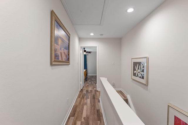 hallway with recessed lighting, attic access, wood finished floors, and an upstairs landing