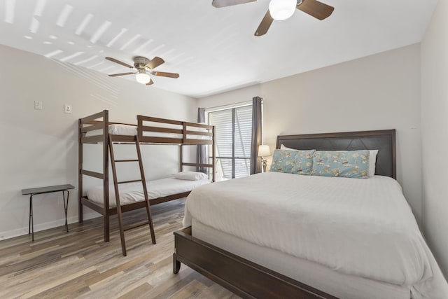 bedroom featuring a ceiling fan, baseboards, and wood finished floors