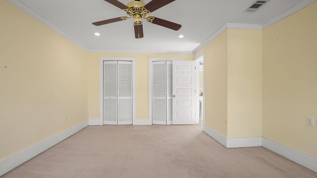 516 College Ave, Defuniak Springs, FL 32435 - unfurnished bedroom with carpet floors, crown molding, two closets, visible vents, and baseboards