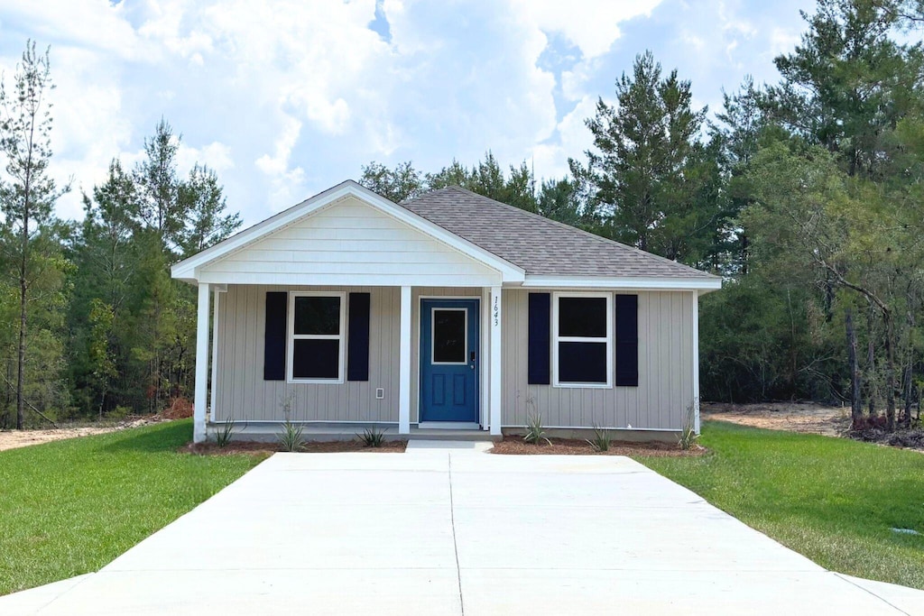 bungalow-style home featuring a porch, a front lawn, and roof with shingles