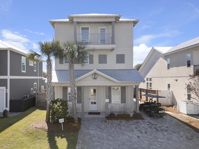 view of front of home with a balcony, fence, and metal roof