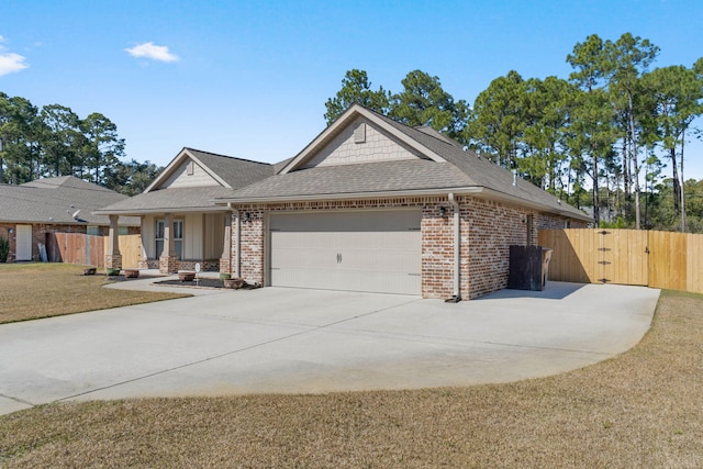 view of front of property with concrete driveway, brick siding, an attached garage, and a gate