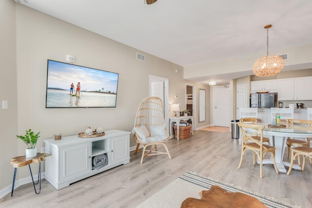 interior space featuring visible vents, light wood-style flooring, and baseboards