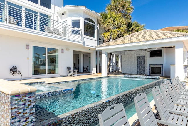 view of pool featuring a patio area, a fireplace, and a pool with connected hot tub