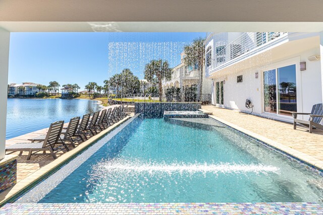 outdoor pool featuring a patio area and a water view