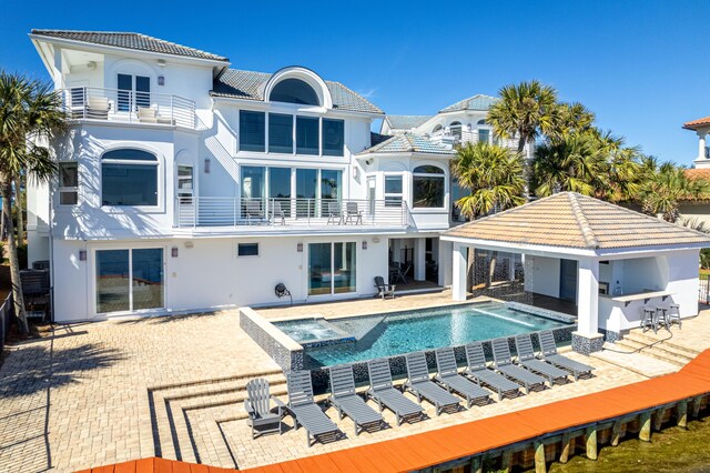 rear view of property with a tile roof, a patio, outdoor dry bar, and a balcony