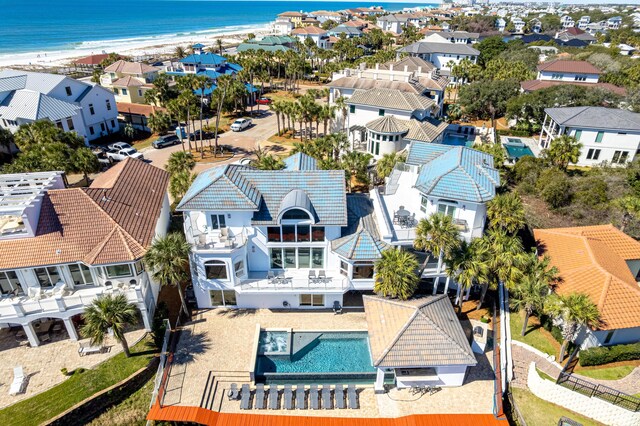 drone / aerial view featuring a residential view, a water view, and a beach view