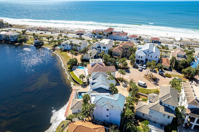 birds eye view of property featuring a water view, a residential view, and a beach view