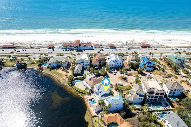 drone / aerial view featuring a water view, a residential view, and a view of the beach