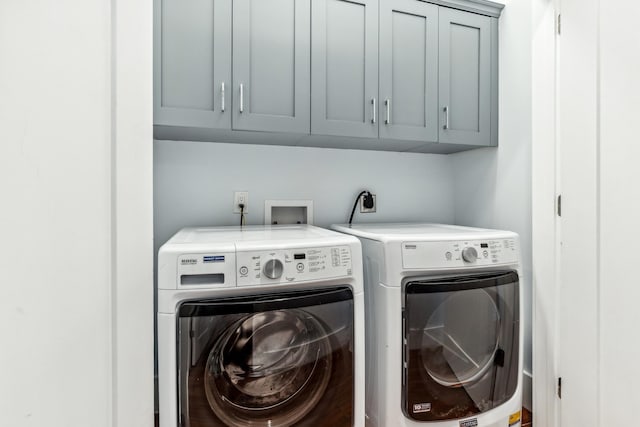 laundry room featuring separate washer and dryer and cabinet space