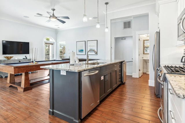 kitchen with visible vents, appliances with stainless steel finishes, wood finished floors, decorative light fixtures, and a sink