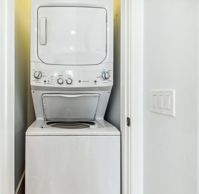 washroom with stacked washing maching and dryer and laundry area